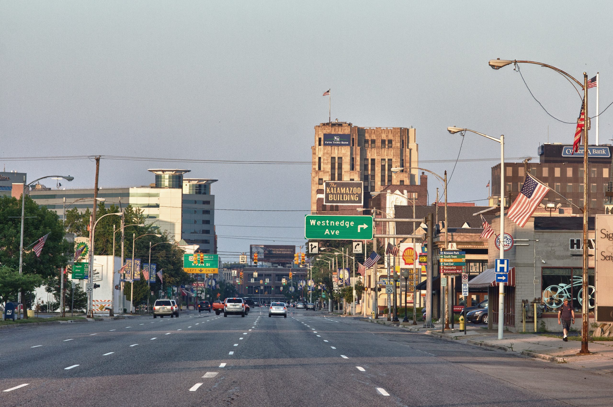Downtown Kalamazoo, Michigan skyline view from Westnedge Avenue with traffic, buildings, and the historic Kalamazoo Building in the background.