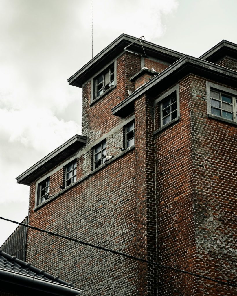 Exterior of an older brick building symbolizing housing instability, eviction risk, and structural barriers to safe housing.