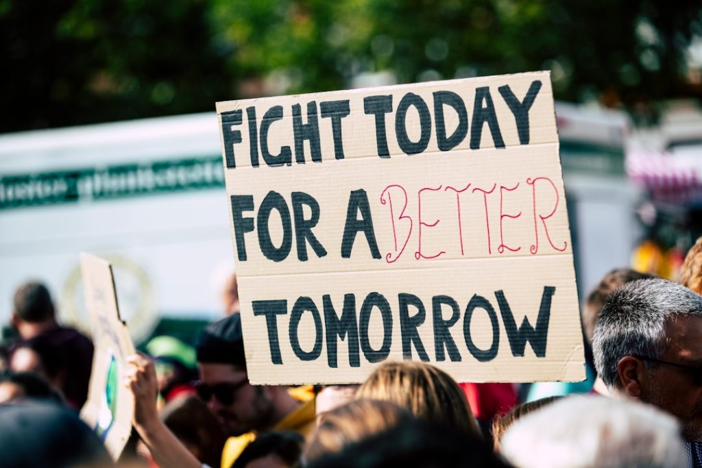 Protest sign reading “Fight today for a better tomorrow,” symbolizing long-term accountability and systemic change.
